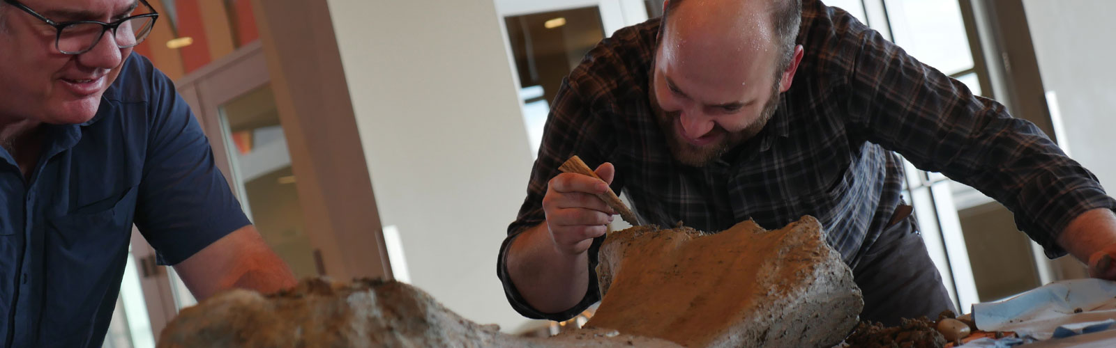 2 men examining mammoth bone