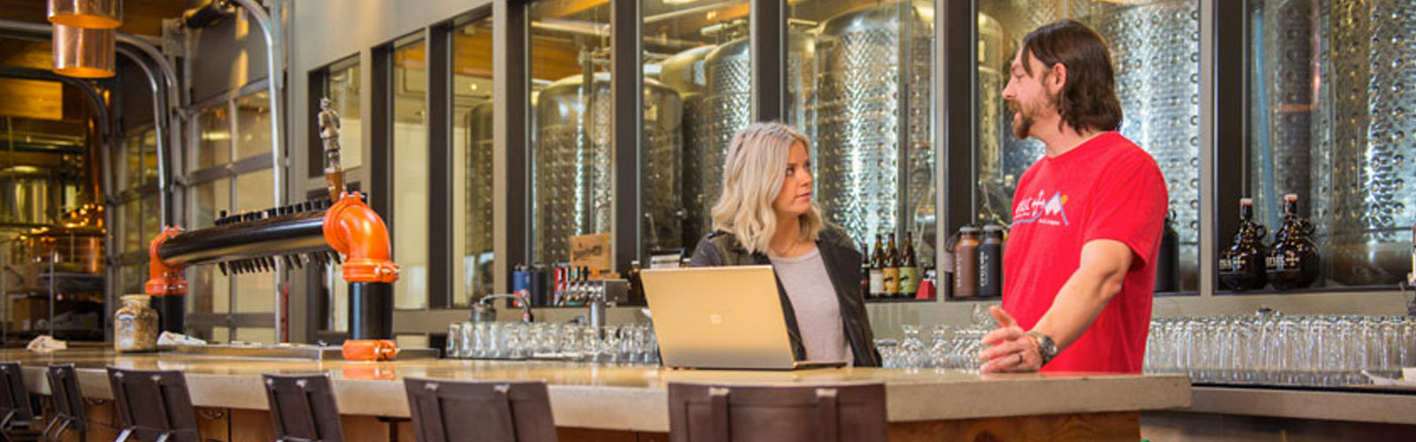 man and woman talking at a bar 