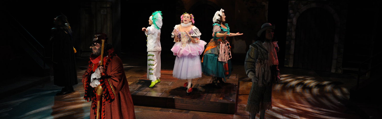 students in colorful costumes acting on a stage
